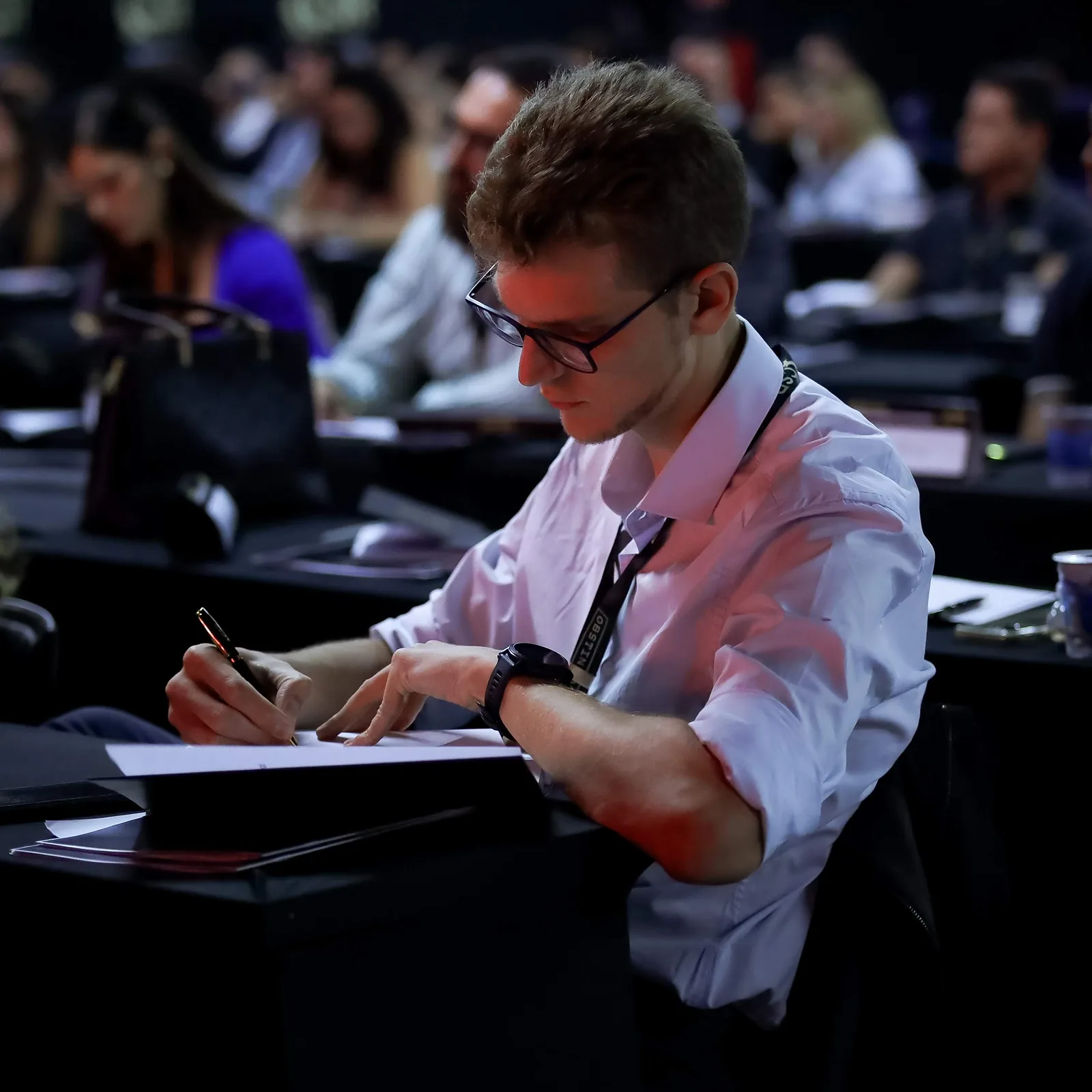 Ricardo Werlang tomando notas na plateia de um evento.