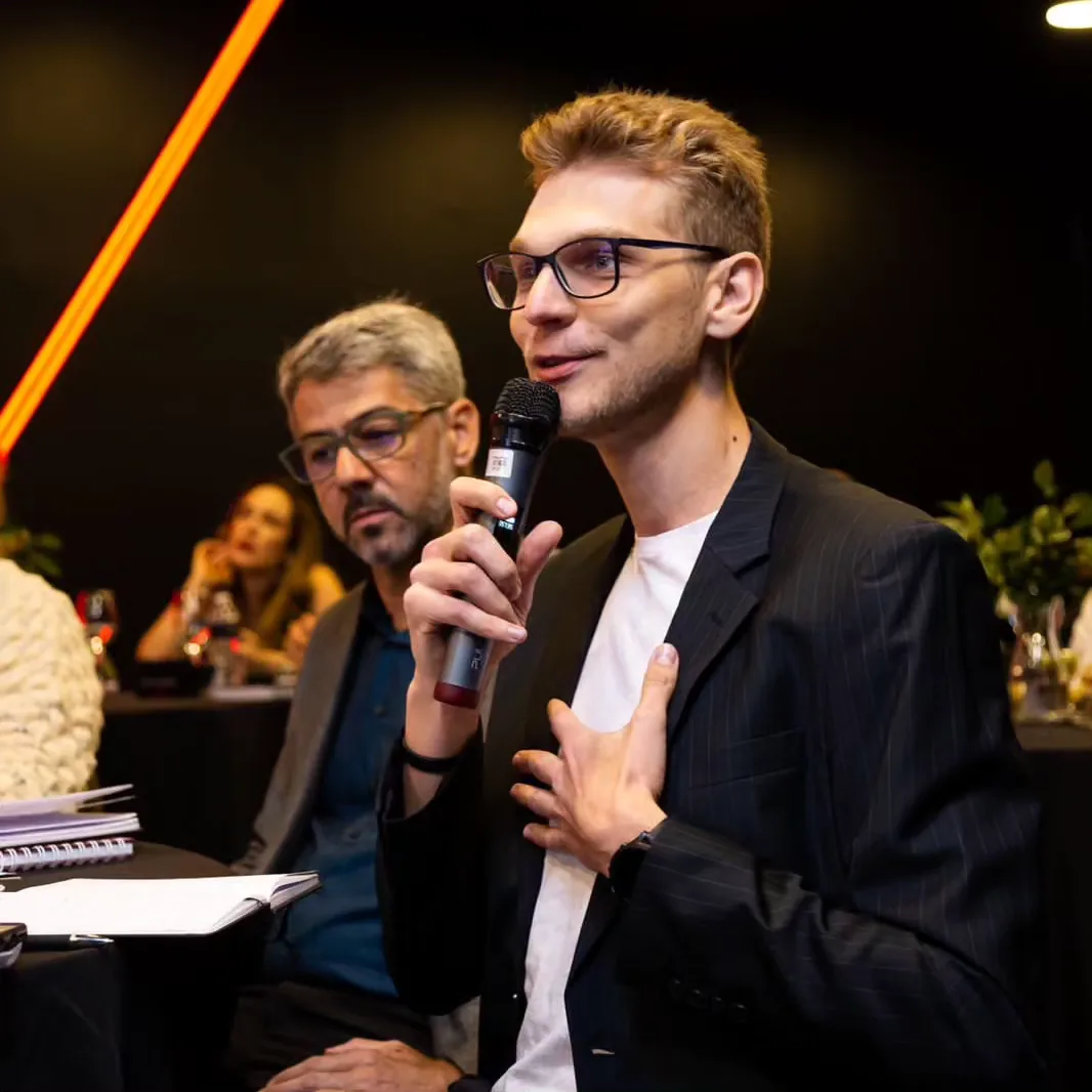 Ricardo Werlang pergunta ao microfone na plateia de um evento.